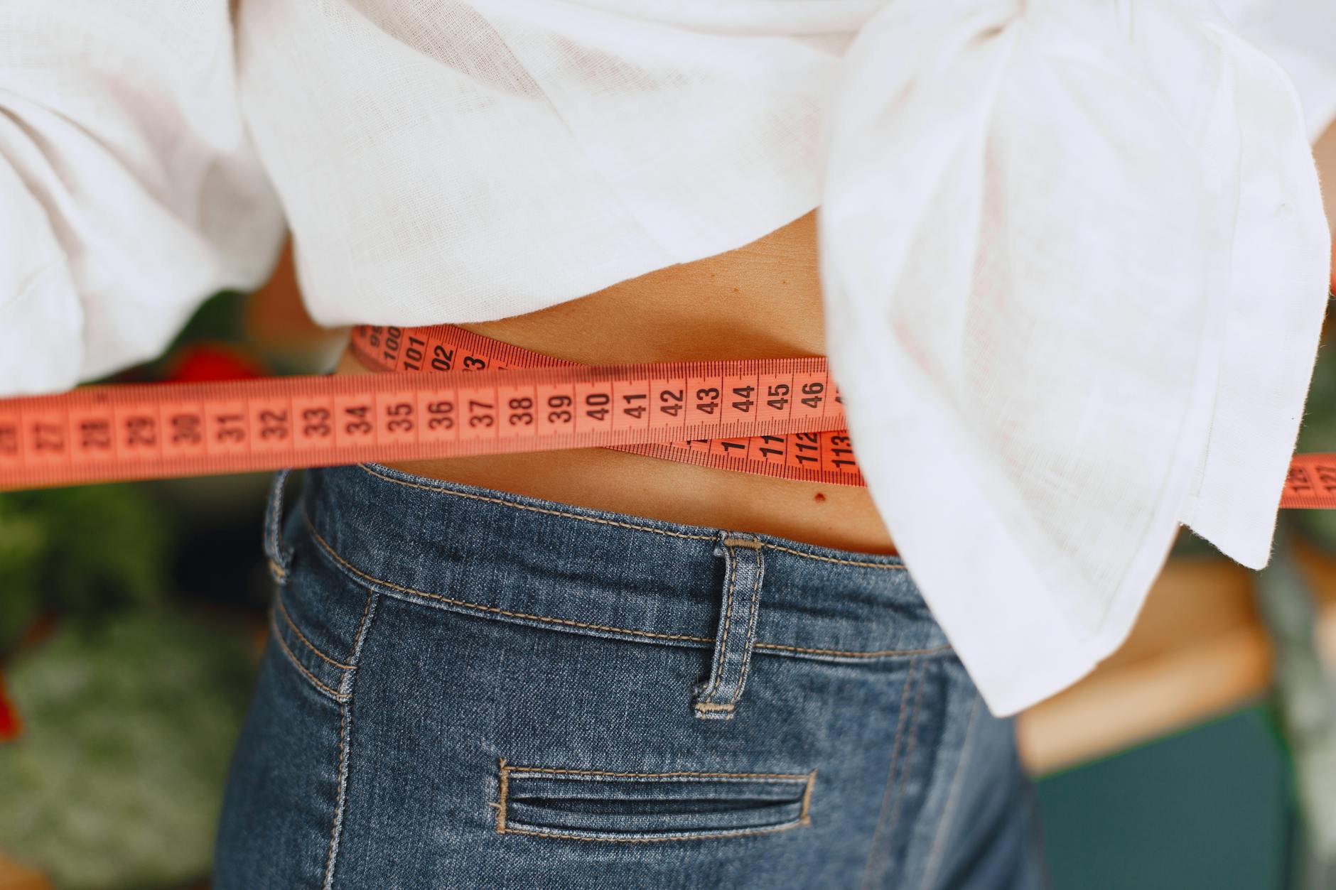 woman measuring waist with tape measure