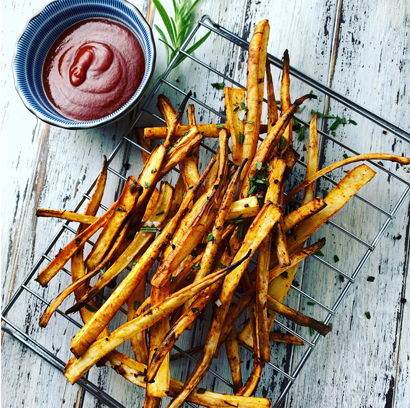 A serving of crispy baked parsnip fries with a side of ketchup.