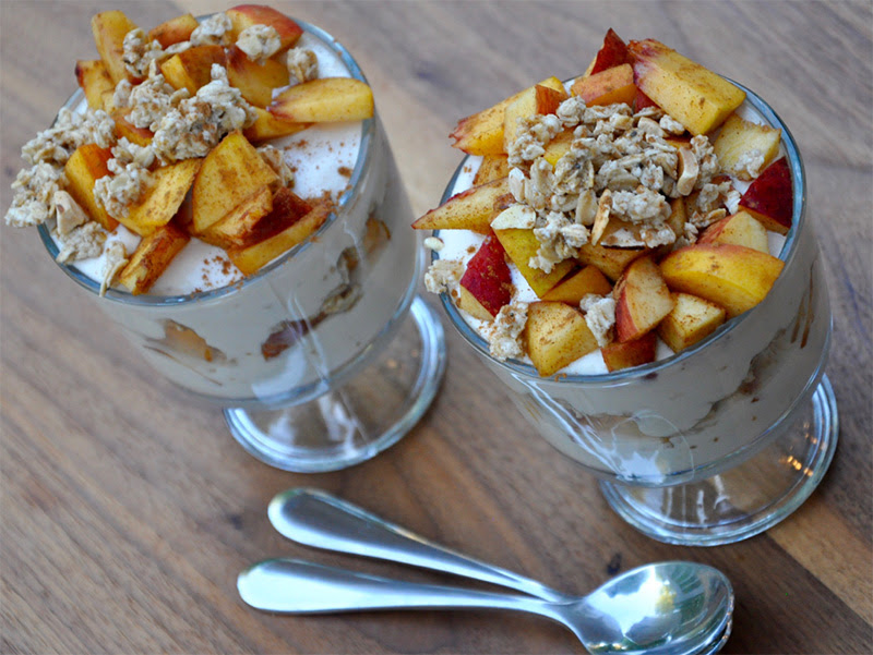 Layered Greek yogurt parfait with fresh fruit and granola in a glass.