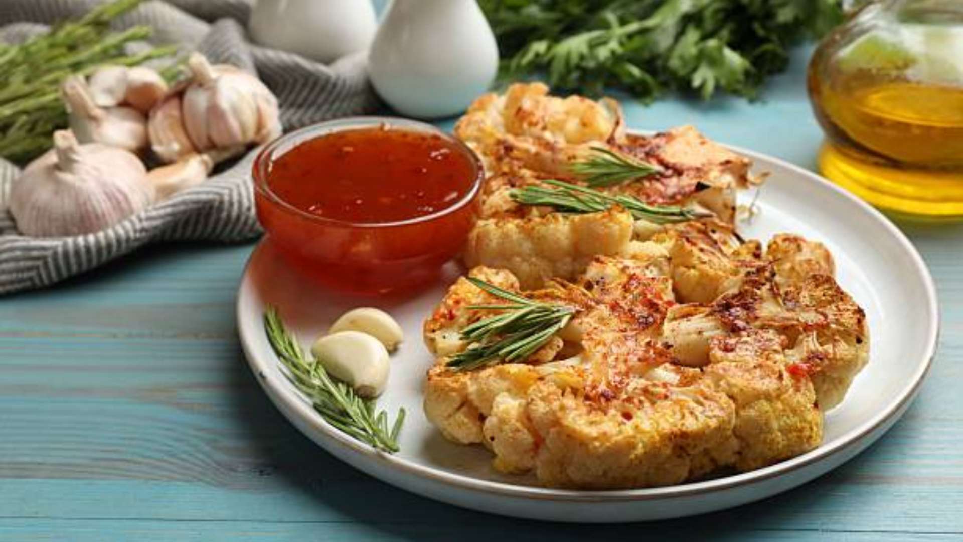 Roasted cauliflower steaks served with herbs and spices, perfect for a healthy snack or side dish.