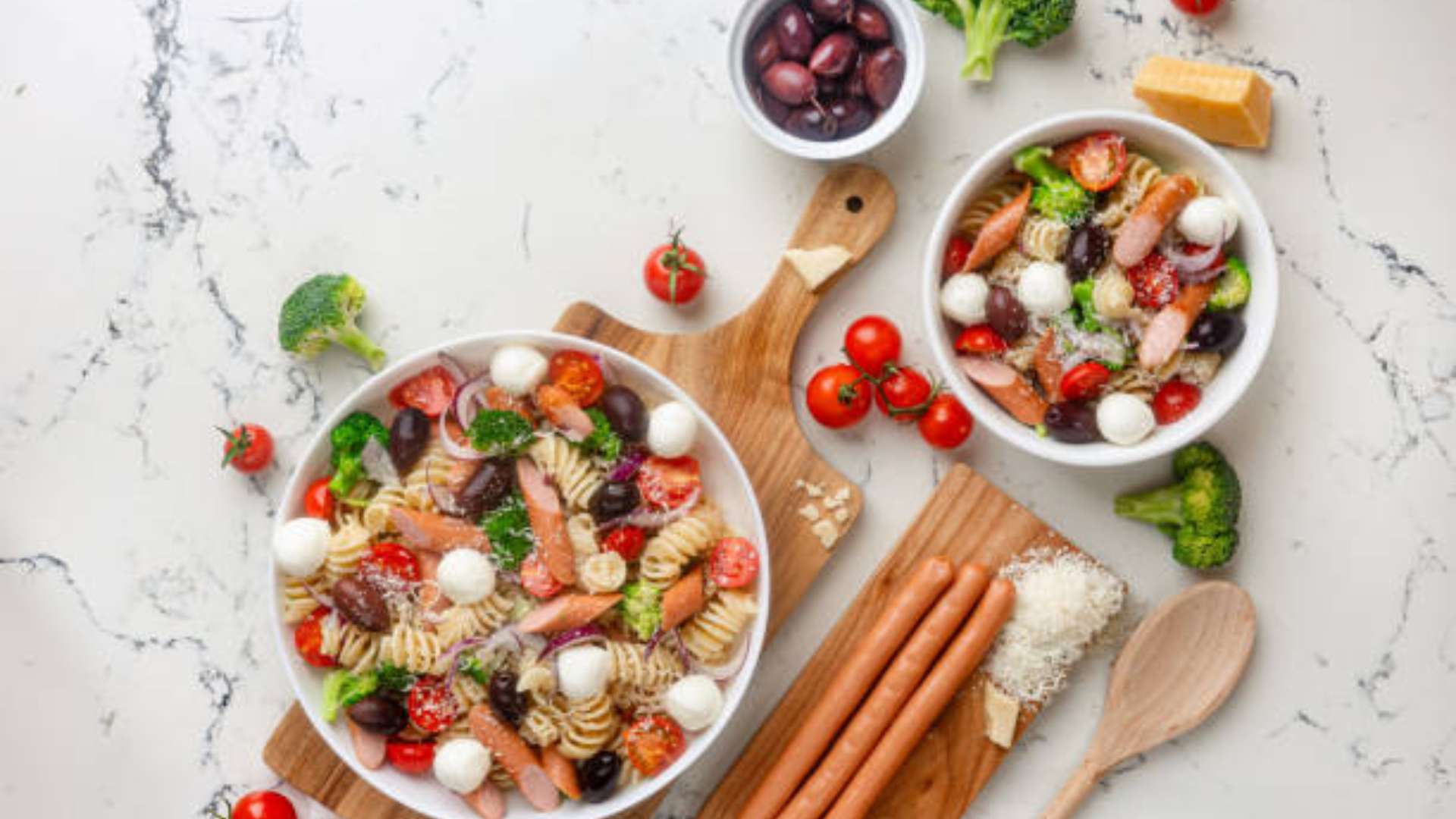 A colorful Italian pasta salad with fresh vegetables and dressing.