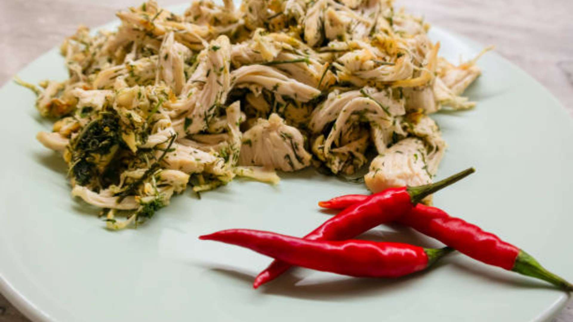 A bowl of slow cooker pulled chicken ready for a healthy meal prep.