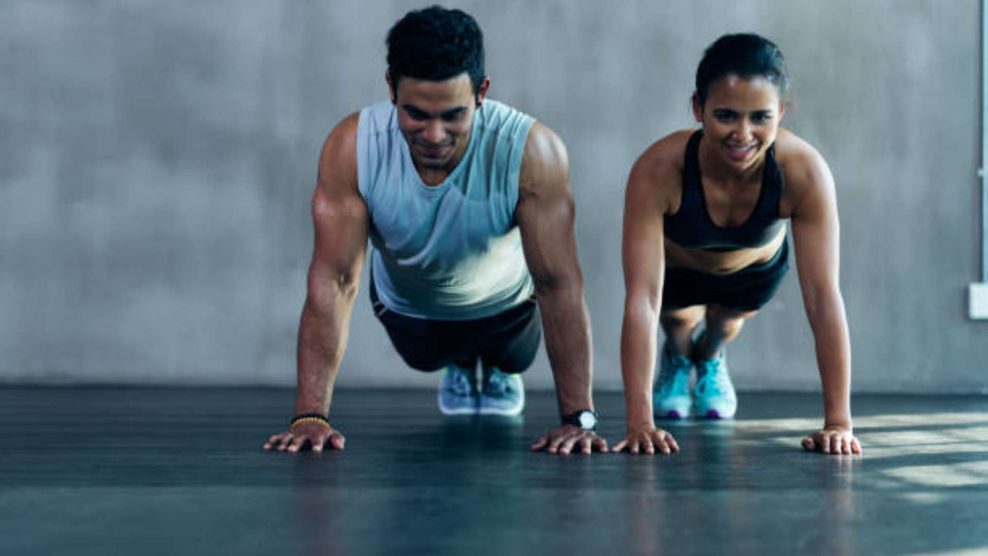 Person performing burpees in a gym to build strength and stamina.