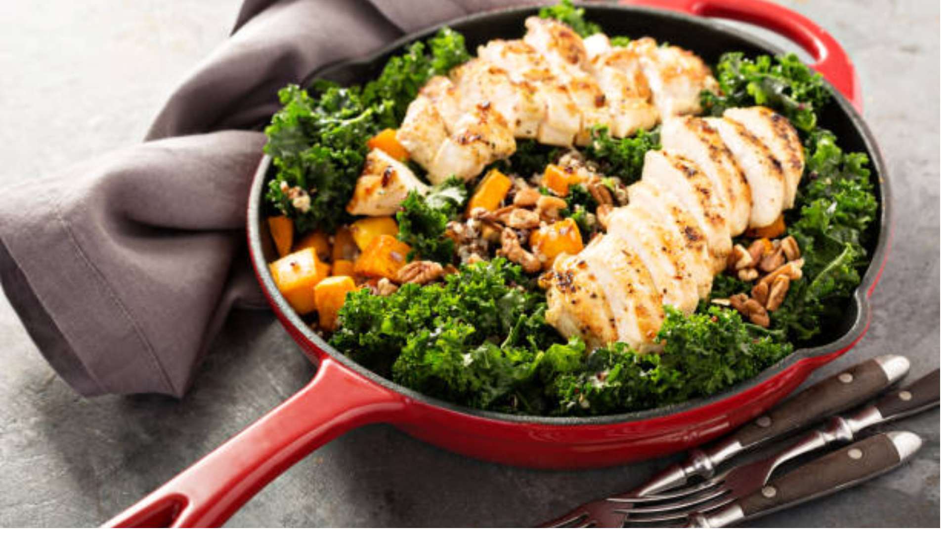 Zesty lemony kale quinoa with turmeric chicken served in a bowl, garnished with pepitas.
