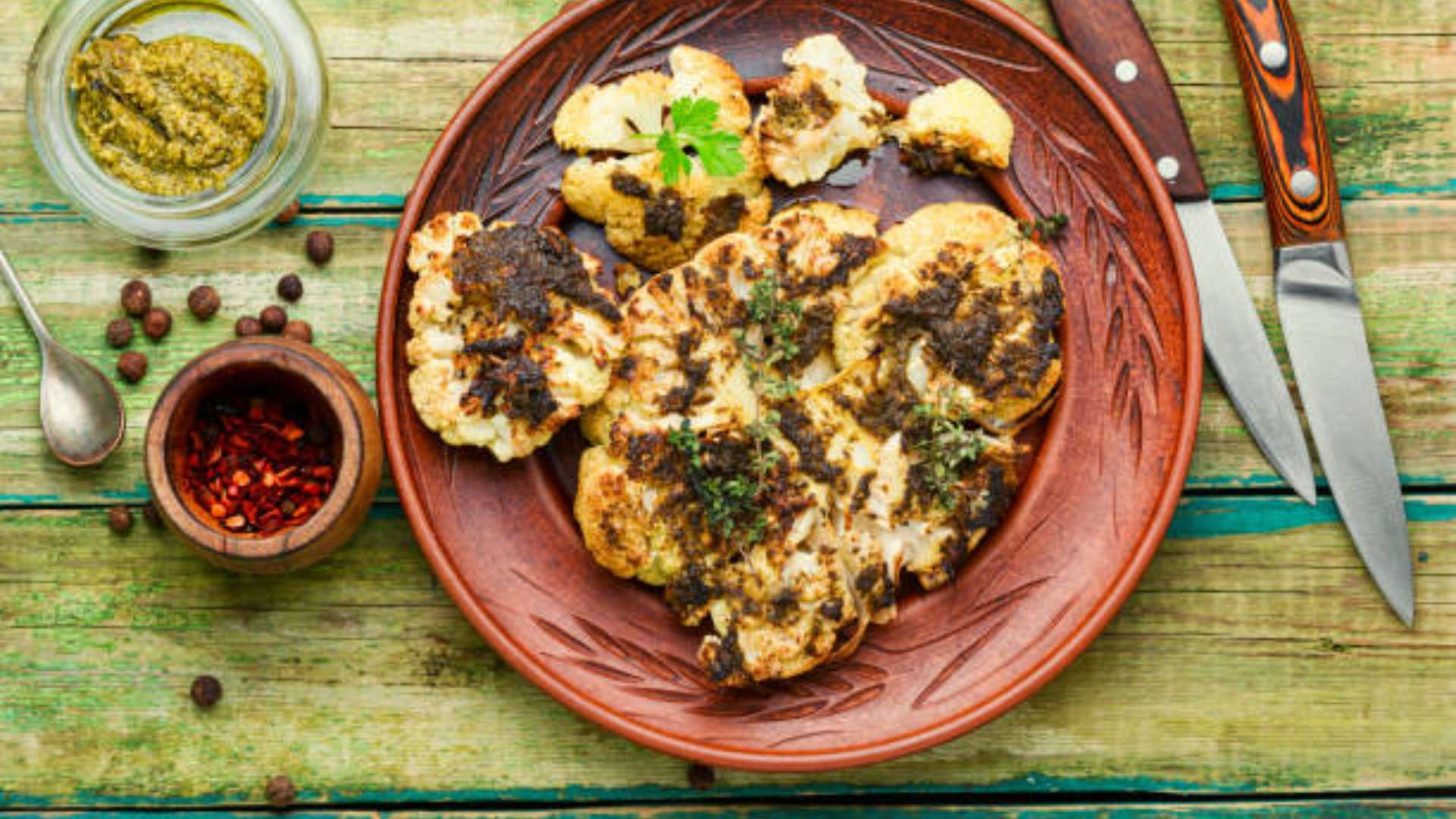 Za’atar roasted cauliflower florets roasted in oven with olive oil and garlic, plated with herbs