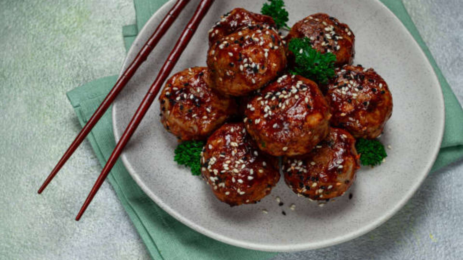 Teriyaki meatballs served on a platter with a drizzle of teriyaki sauce