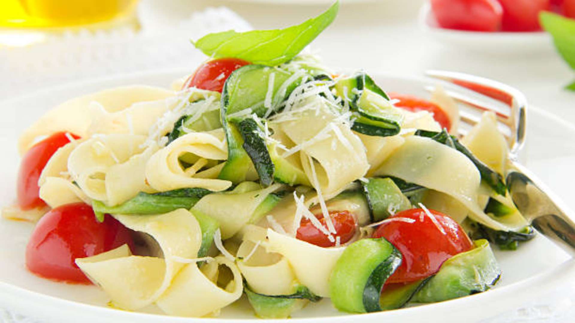 Flat zucchini noodles topped with Parmesan cheese, a healthy pasta alternative.