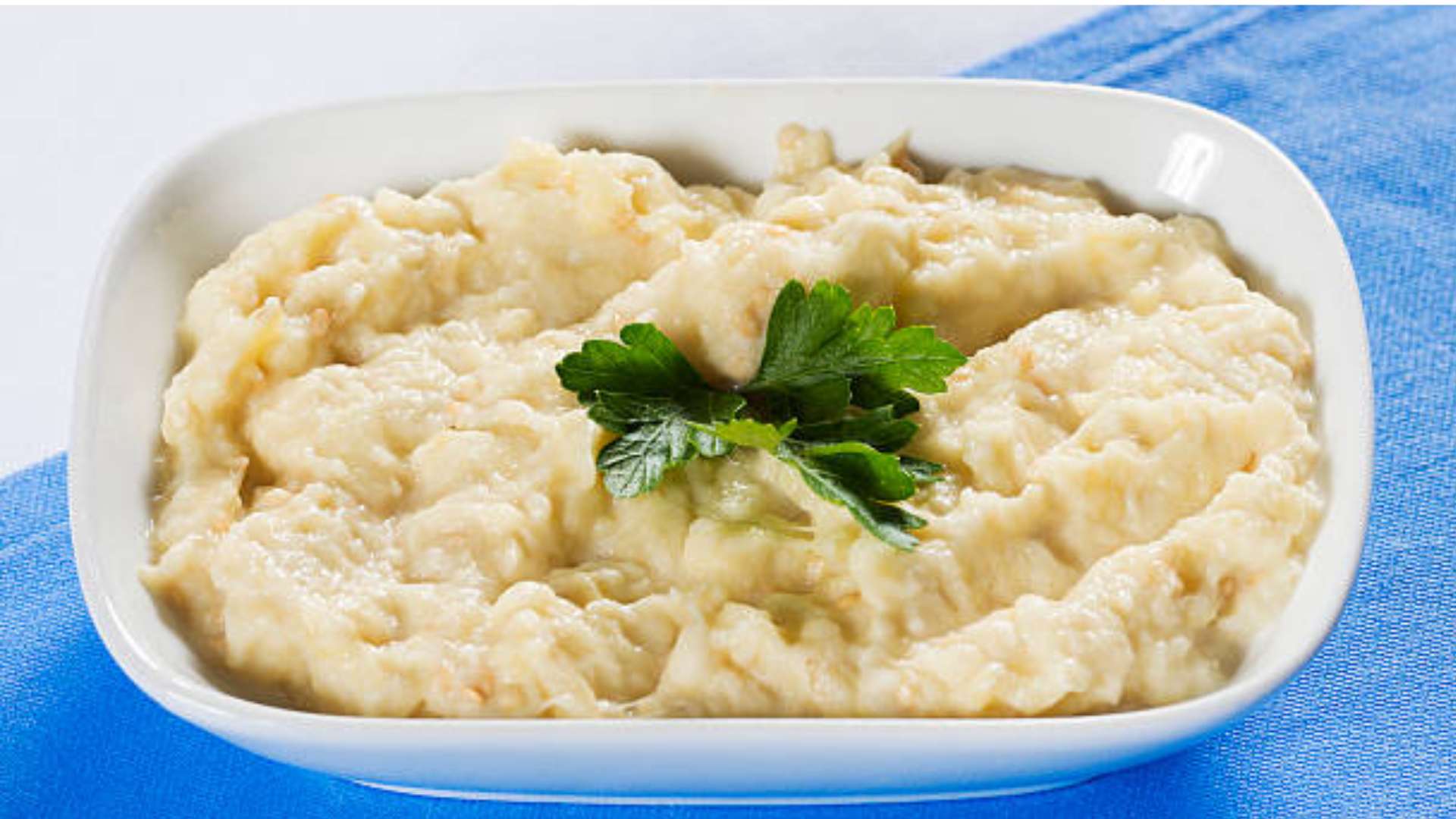 Creamy Cauliflower Smash topped with chives in a serving bowl